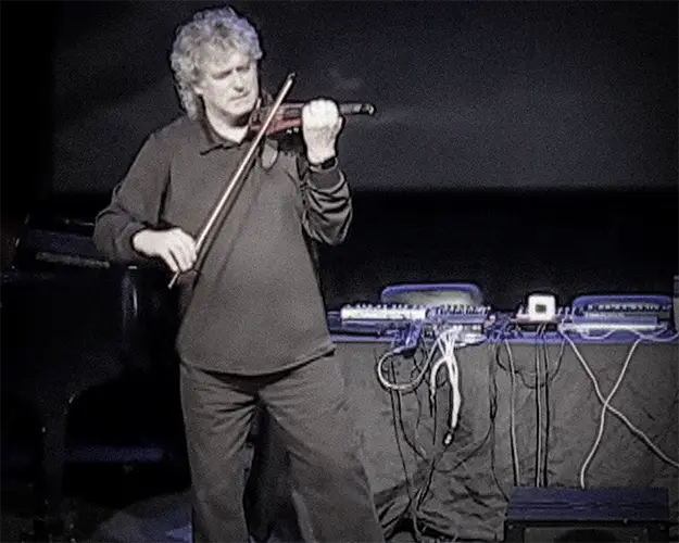 Mark Zaki performing violin beside electronic equipment